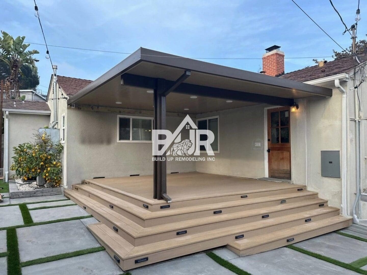 Modern backyard deck with a pergola and multi-level steps.