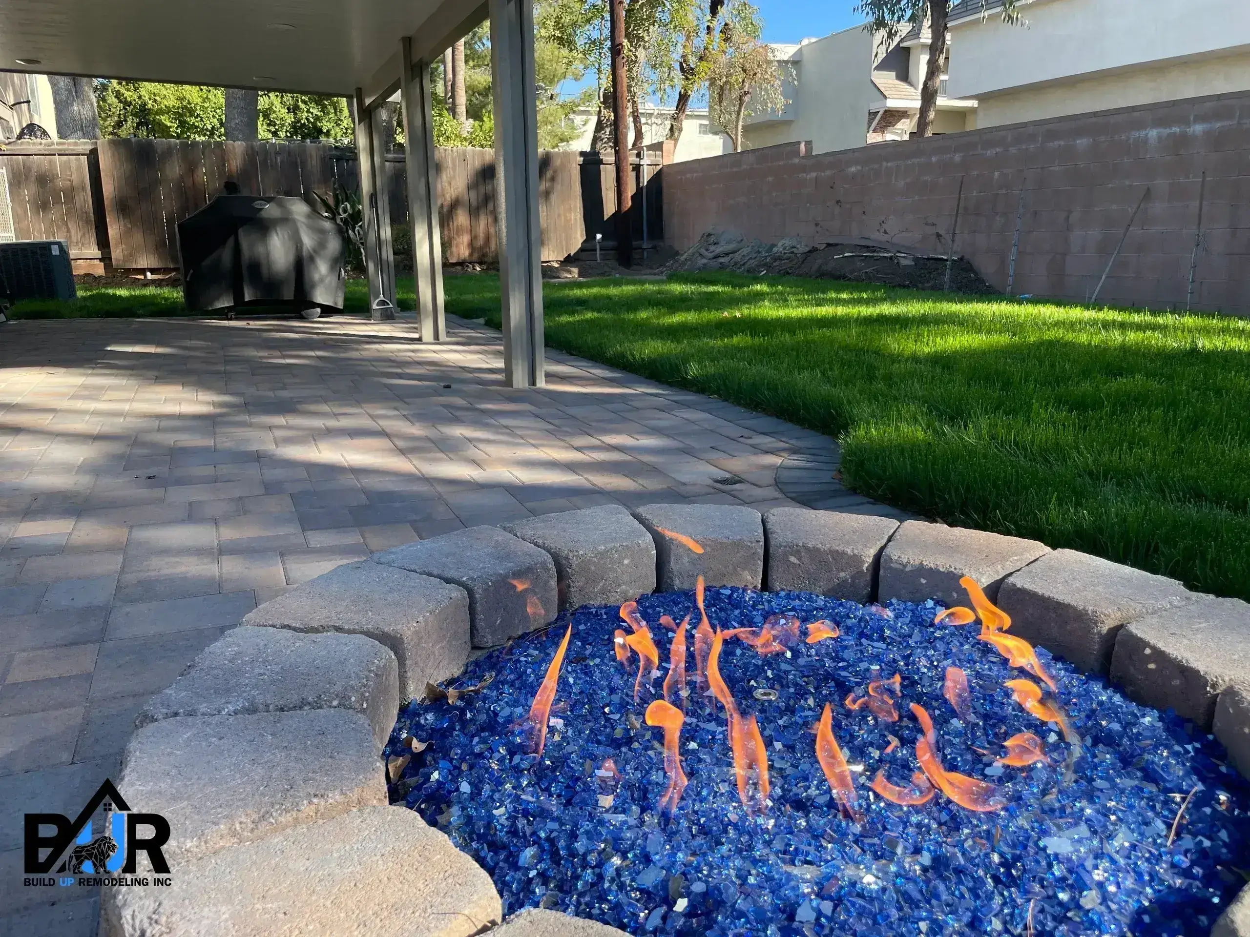 Outdoor fire pit with blue glass stones and dancing flames.