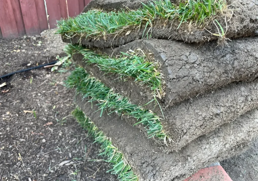 Stacked rolls of fresh green sod grass.